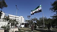 جنود سوريون يرفعون العلم الوطني السوري أمام مبنى وزارة الدفاع السورية ، الذي تضرر بشدة من الغارات الجوية الإسرائيلية يوم الأربعاء الماضي ، في دمشق ، سوريا ، السبت 19 تموز