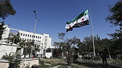 جنود سوريون يرفعون العلم الوطني السوري أمام مبنى وزارة الدفاع السورية ، الذي تضرر بشدة من الغارات الجوية الإسرائيلية يوم الأربعاء الماضي ، في دمشق ، سوريا ، السبت 19 تموز 