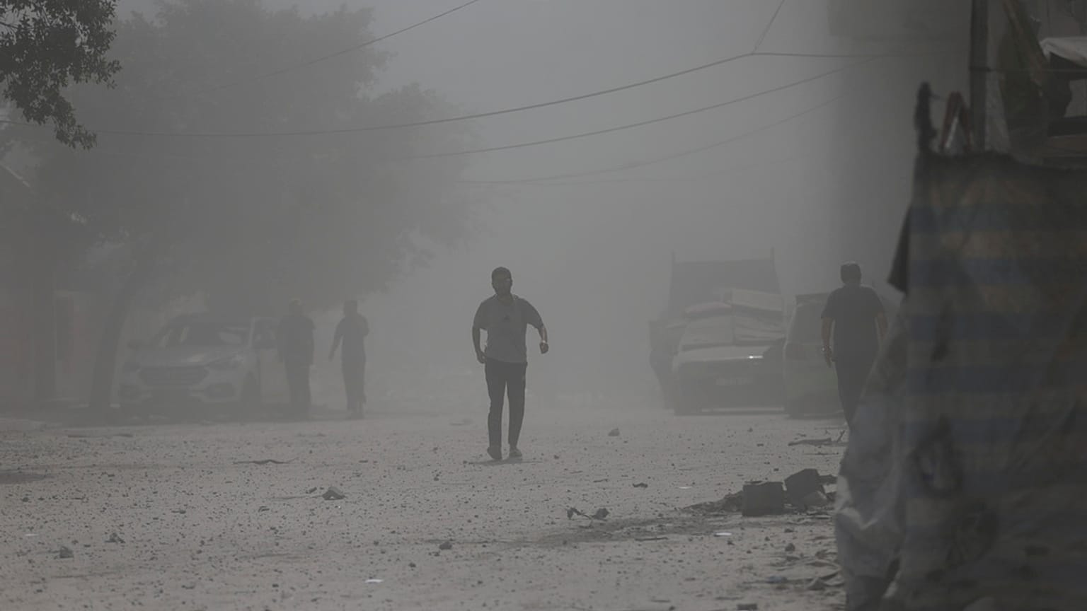 Palestinianos caminham no meio do pó levantado por ataque israelita na Cidade de Gaza na segunda-feira, 15 de setembro