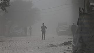 Palestinianos caminham no meio do pó levantado por ataque israelita na Cidade de Gaza na segunda-feira, 15 de setembro