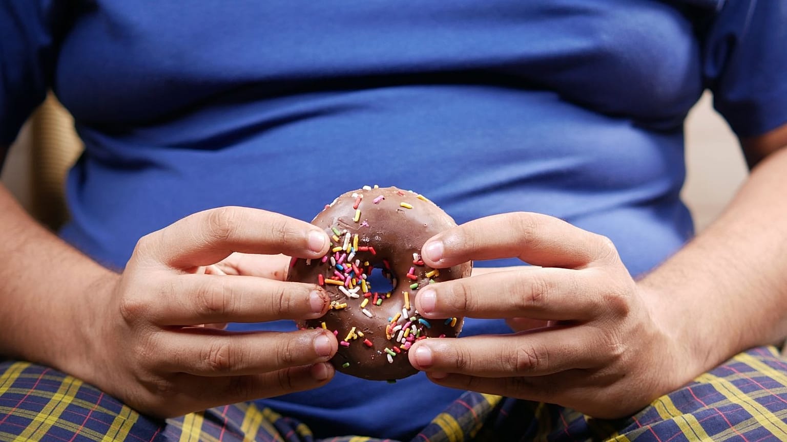 A person holds a donut.