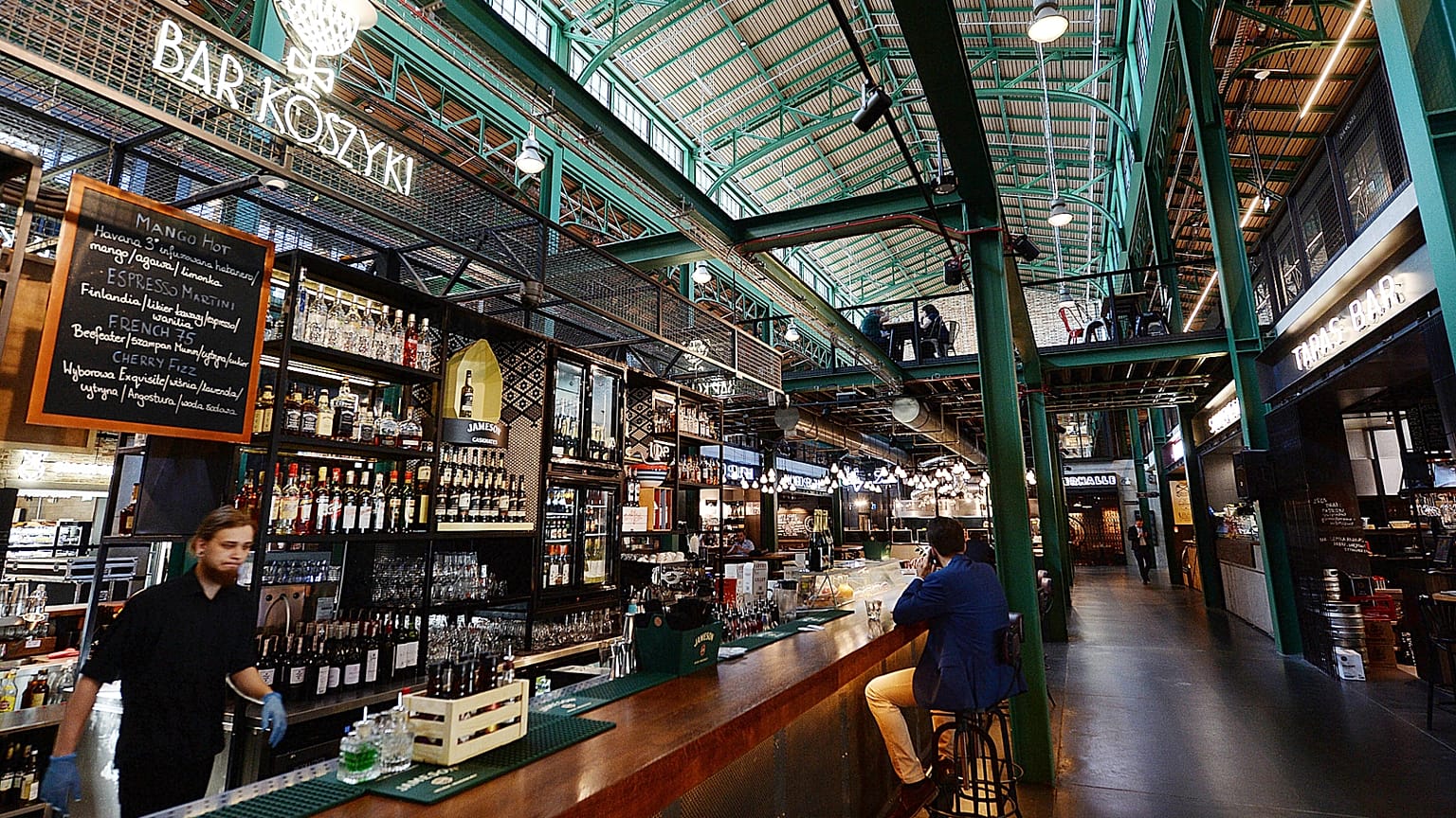 Barman pracuje w warszawskiej Hali Koszyki, hali targowej z początku XX wieku, która została odnowiona i przekształcona w nowoczesną galerię restauracji.