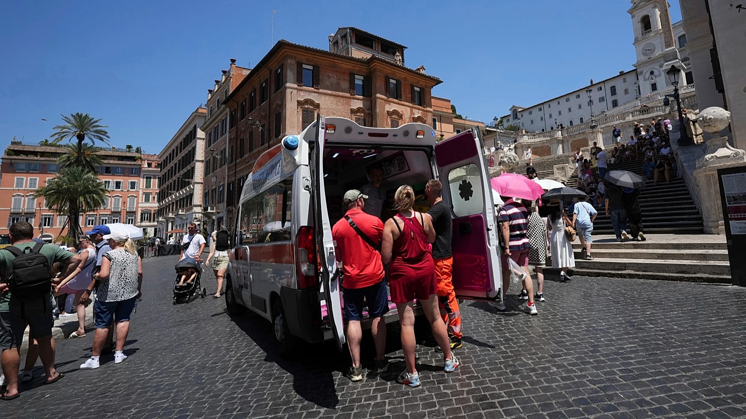 Paramedics provide aid to tourists and residents with an ambulance, next to the historical Spanish Steps, in Rome, Italy, July 1, 2025.