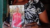 FILE: Rose Wanyua Wanjiku, elder sister to Agnes Wanjiru, 20, holds a photograph of Agnes, at Rose's house in the Majengo informal settlement in Nanyuki, Kenya, Nov. 4, 2021