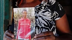 FILE: Rose Wanyua Wanjiku, elder sister to Agnes Wanjiru, 20, holds a photograph of Agnes, at Rose's house in the Majengo informal settlement in Nanyuki, Kenya, Nov. 4, 2021