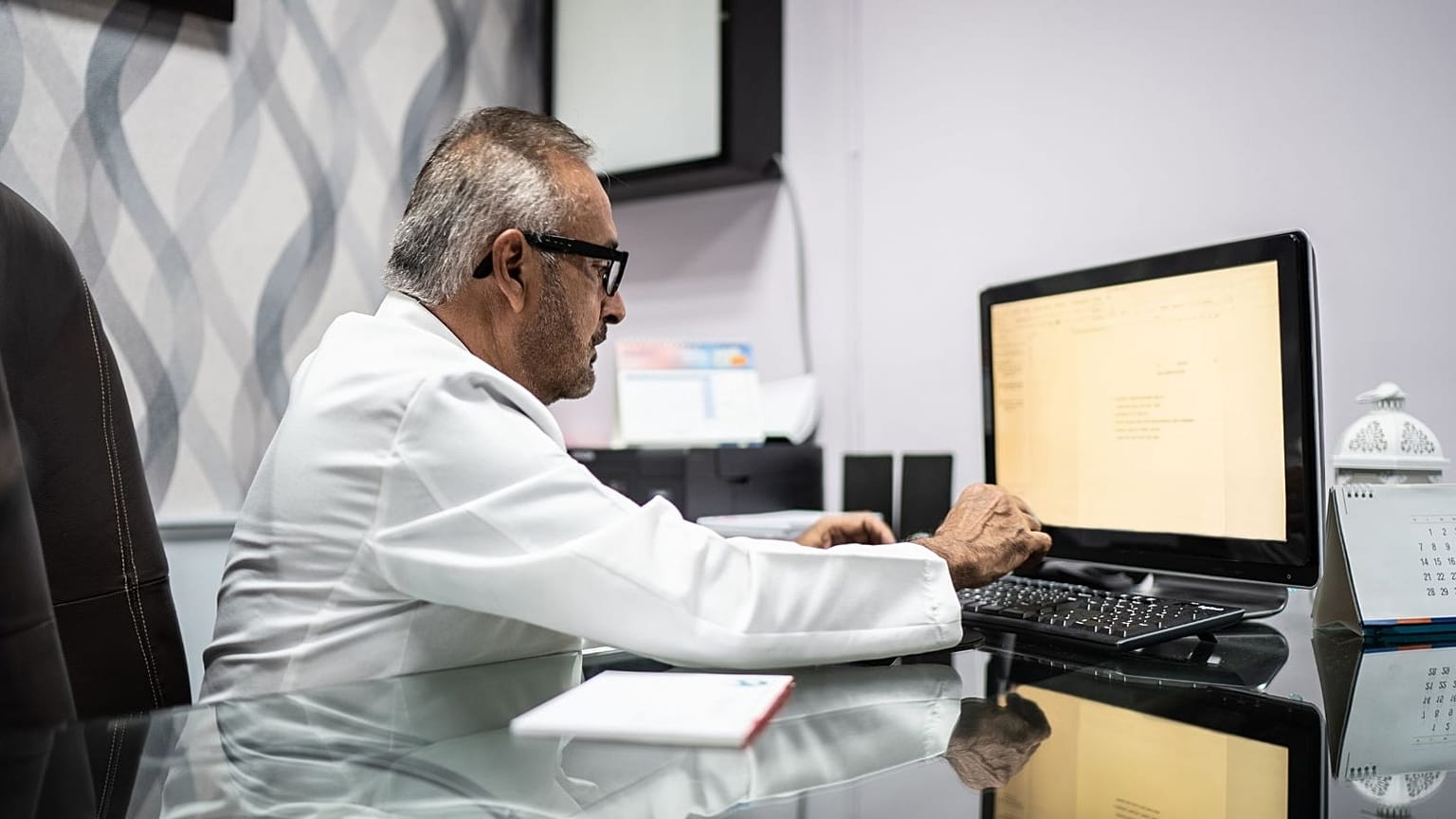 A doctor works at a computer.