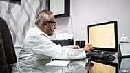 A doctor works at a computer.