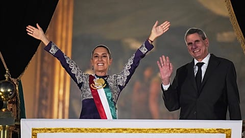 President Claudia Sheinbaum, left, and her husband Jesus Maria Tarriba wave to the crowd during the annual independence shout from the balcony of the National Palace to kick o