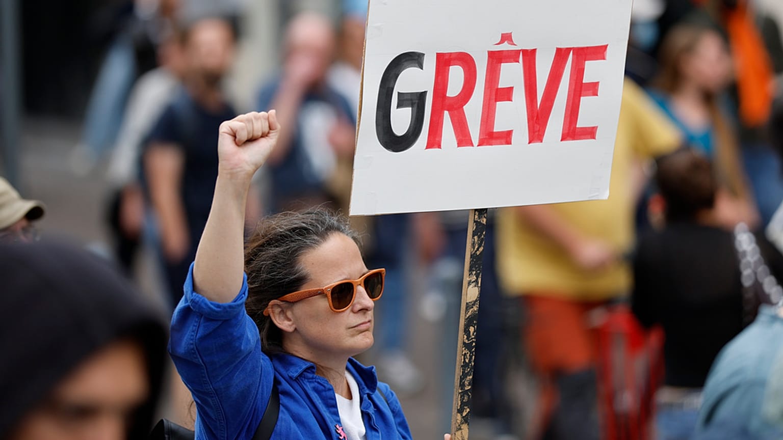 Une manifestante brandit une pancarte sur laquelle on peut lire « grève » lors d'un rassemblement du mouvement « Bloquons tout » à Lille, le 10 septembre