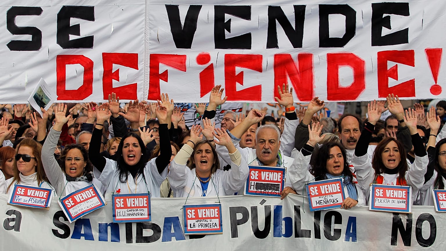 FILE. Protestors hold a banner reading: "Our public health service is not for sale, it’s to be defended!" in Spain in 2012.