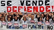 FILE. Protestors hold a banner reading: "Our public health service is not for sale, it’s to be defended!" in Spain in 2012.