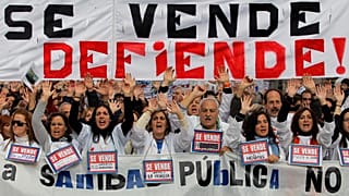 FILE. Protestors hold a banner reading: "Our public health service is not for sale, it’s to be defended!" in Spain in 2012.