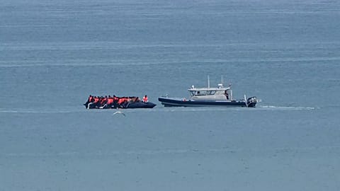 A boat thought to carry migrants is escorted by a vessel from the French Gendarmerie Nationale in the English Channel, 4 September, 2024