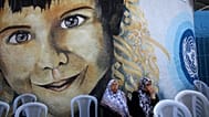FILE: Women sit near the entrance to the United Nations Relief and Works Agency headquarters (UNRWA) during a protest in Gaza City, 19 July 2017