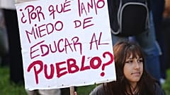 Ein Demonstrant hält ein Schild mit der spanischen Aufschrift "Warum so viel Angst, die Menschen zu erziehen?"