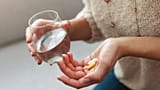 A woman holds supplements.