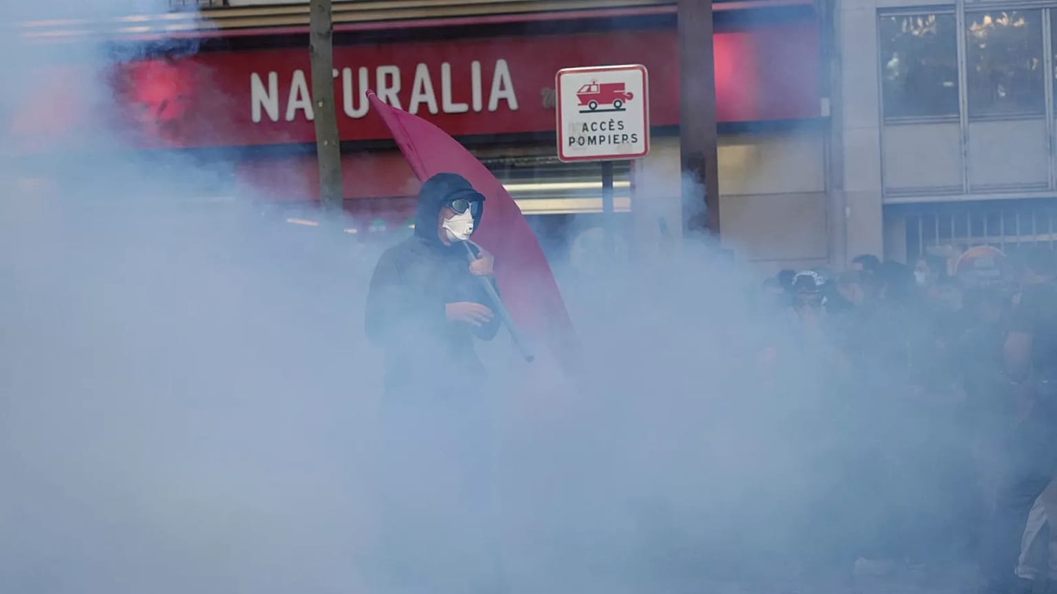 A protester stands in tear gas smoke during a demonstration in Paris, 18 September, 2025