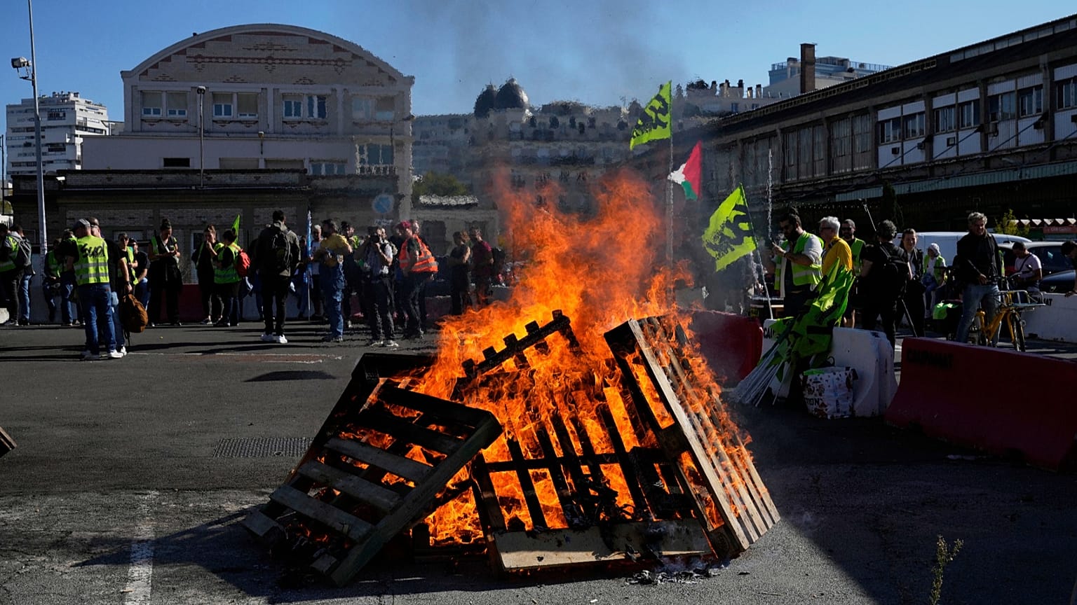 Workers gather next wooden pallets on fire at the Gare de Lyon train station during a protest called by major trade unions to oppose budget cuts, in Paris, 18 September 2025