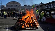 Workers gather next wooden pallets on fire at the Gare de Lyon train station during a protest called by major trade unions to oppose budget cuts, in Paris, 18 September 2025