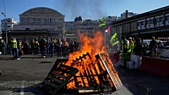 Des travailleurs se rassemblent à côté de palettes en bois en feu à la gare de Lyon, à Paris, le jeudi 18 septembre 2025.