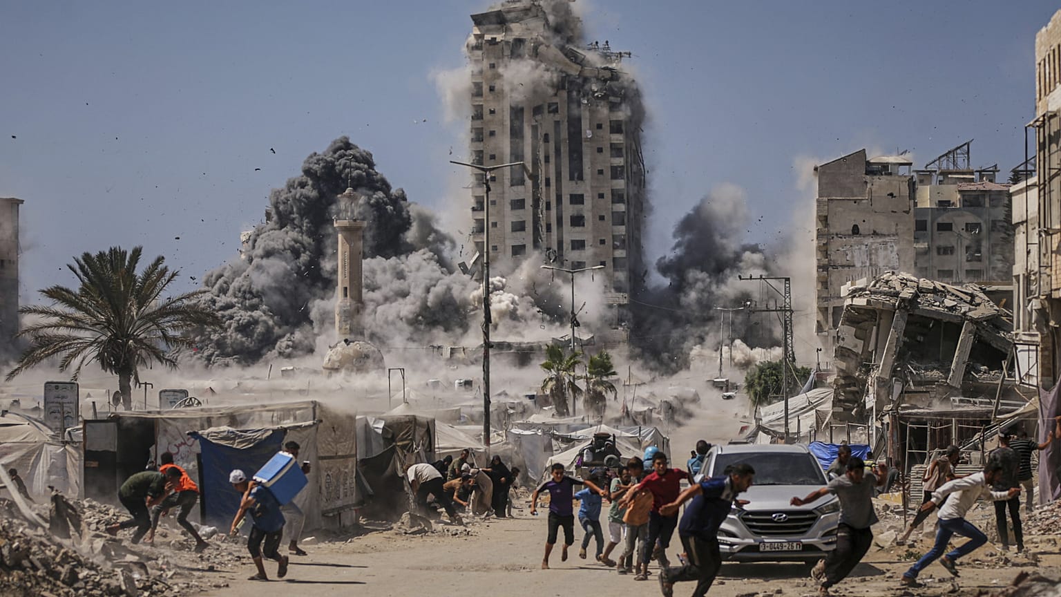 يركض فلسطينيون بحثًا عن غطاء خلال غارة جوية إسرائيلية على مبنى شاهق في مدينة غزة، الجمعة 5 سبتمبر 2025، بعد أن أصدر الجيش الإسرائيلي تحذيرًا مسبقًا. 