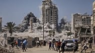 يركض فلسطينيون بحثًا عن غطاء خلال غارة جوية إسرائيلية على مبنى شاهق في مدينة غزة، الجمعة 5 سبتمبر 2025، بعد أن أصدر الجيش الإسرائيلي تحذيرًا مسبقًا. 