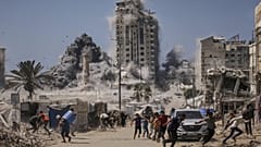 يركض فلسطينيون بحثًا عن غطاء خلال غارة جوية إسرائيلية على مبنى شاهق في مدينة غزة، الجمعة 5 سبتمبر 2025، بعد أن أصدر الجيش الإسرائيلي تحذيرًا مسبقًا. 
