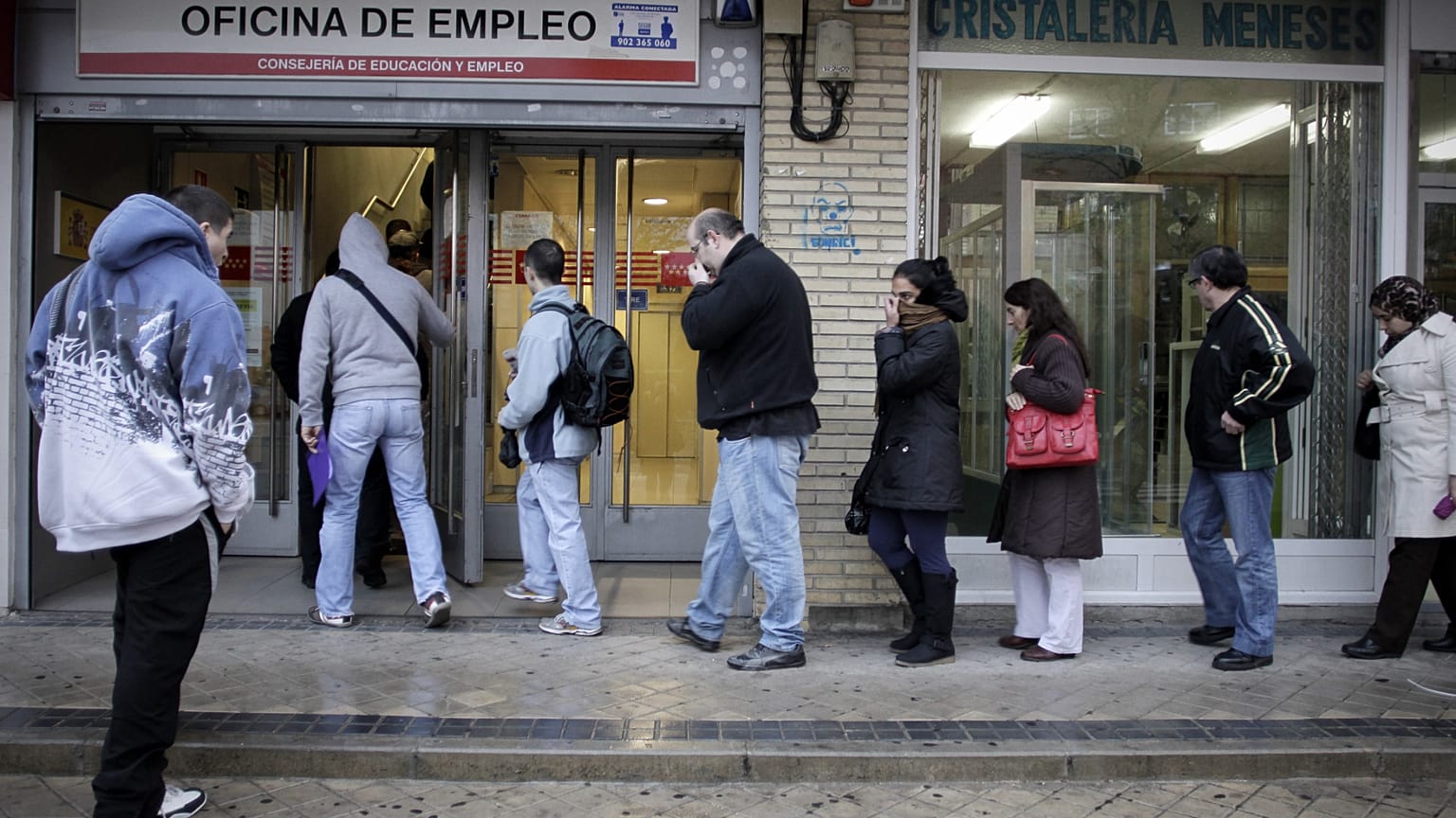 FILE. People queue outside an unemployment registry office in Madrid in 2011.