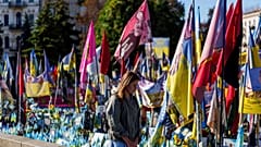 Una mujer observa fotografías en un memorial de soldados ucranianos caídos en la plaza de la independencia en Kiev, Ucrania, el jueves 18 de septiembre de 2025.