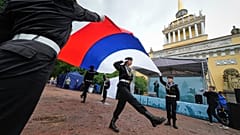 Mitglieder eines Clubs junger Marinesoldaten tragen die russische Nationalflagge während der Feierlichkeiten zum russischen Nationalfeiertag in St. Petersburg, Russland, am 22. August 2025.