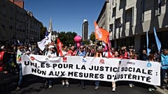 Demonstranten marschieren bei einem Protest, zu dem große Gewerkschaften aufgerufen haben, um gegen Budgetkürzungen zu protestieren.