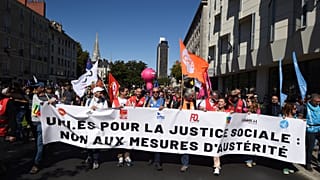 Des manifestants défilent lors d'une protestation organisée par les principaux syndicats pour s'opposer aux coupes budgétaires