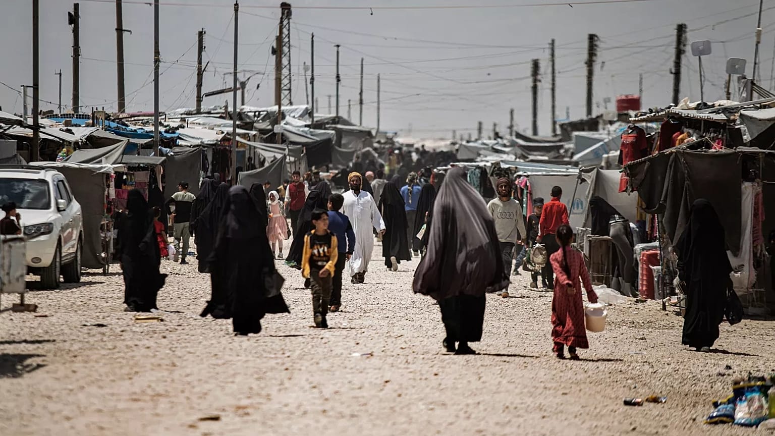 Family members of suspected Islamic State group fighters walk at al-Hol camp in Syria, 8 May, 2024