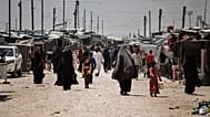 Family members of suspected Islamic State group fighters walk at al-Hol camp in Syria, 8 May, 2024