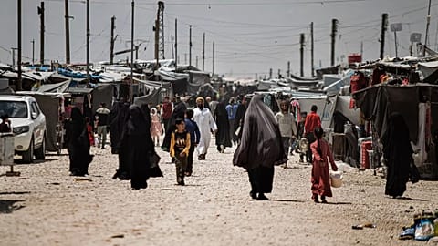 Family members of suspected Islamic State group fighters walk at al-Hol camp in Syria, 8 May, 2024