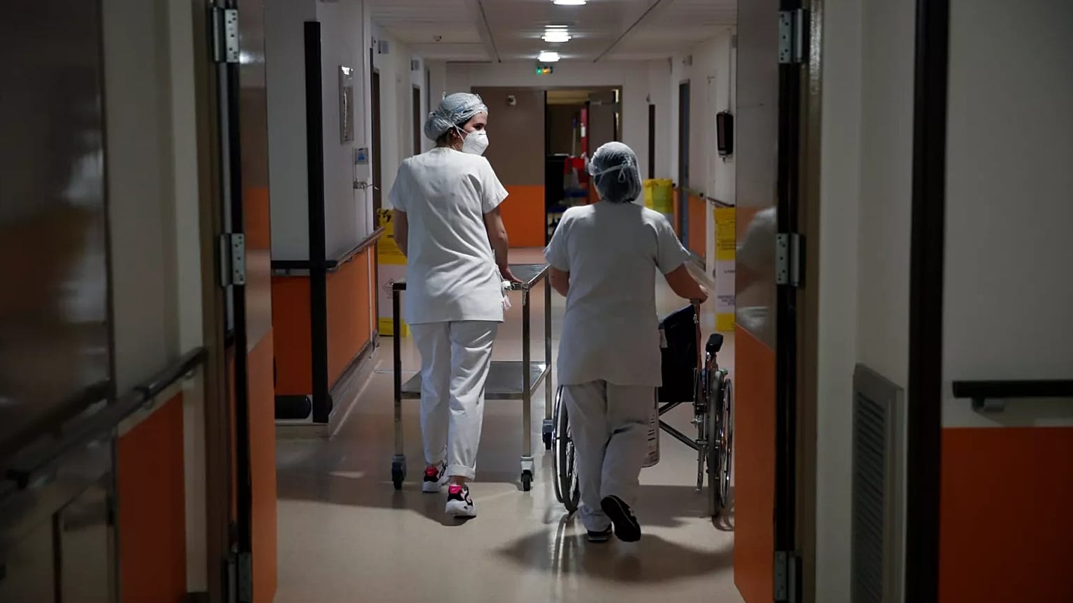 Medical staffers walk through the corridor of the Porte Verte Hospital in Versailles, France, on April 2, 2021.