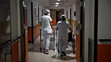 Medical staffers walk through the corridor of the Porte Verte Hospital in Versailles, France, on April 2, 2021.