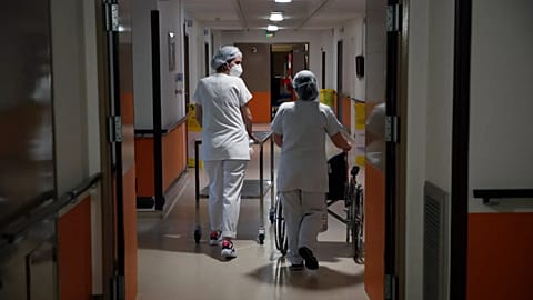 Medical staffers walk through the corridor of the Porte Verte Hospital in Versailles, France, on April 2, 2021.