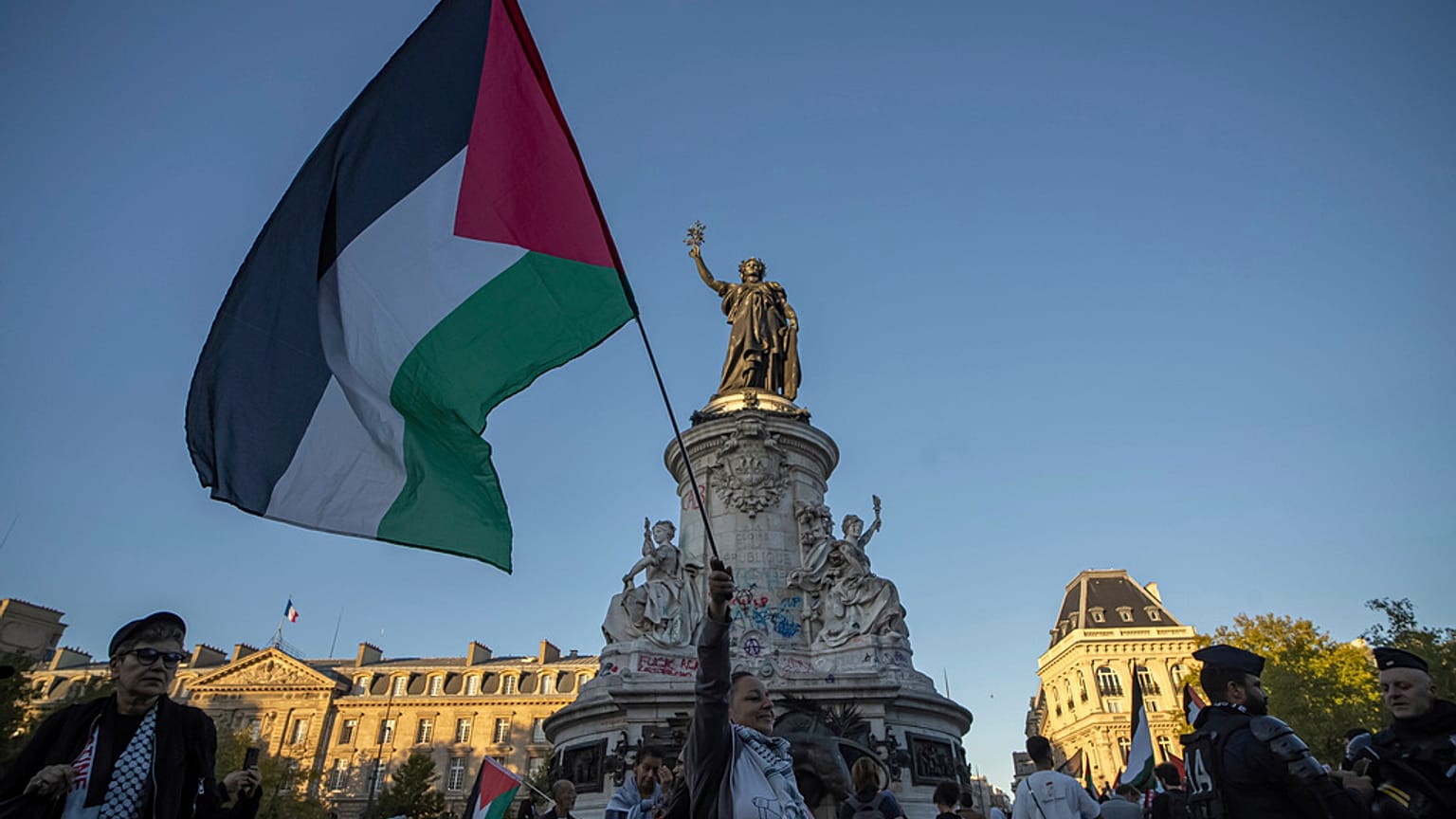 صورة تعبيرية لامرأة تحمل العلم الفلسطيني خلال تجمع مؤيد للفلسطينيين في ساحة الجمهورية في باريس
