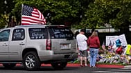 A truck flies a US flag with messages written on the windows in tribute to Charlie Kirk as people gather at a memorial at Utah Valley University in Orem, 13 September 2025