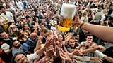 Eyes on the prize: Oktoberfest goers reach out for the first glasses of beer in Munich 
