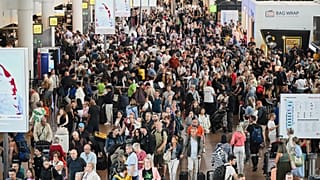 People walk by a departures board after a cyber attack caused delays at Brussels International Airport in Zaventem, Belgium, Saturday, Sept. 20, 2025.