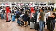 People stand in a line to check in after a cyber attack caused delays at Brussels International Airport in Zaventem, Belgium, Saturday, Sept. 20, 2025.