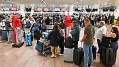Menschen stehen in einer Schlange, um einzuchecken, nachdem ein Cyberangriff am internationalen Flughafen Brüssel in Zaventem, Belgien, am Samstag, 20. September 2025, zu Verzögerungen geführt hat. 