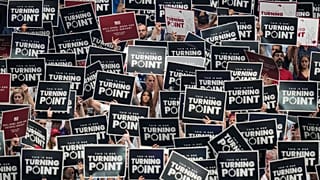 People hold up signs during a memorial for conservative activist Charlie Kirk, 21 September 2025