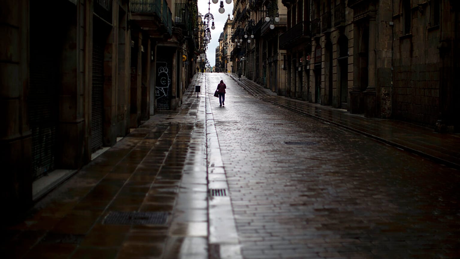 Una persona camina bajo la lluvia en Barcelona