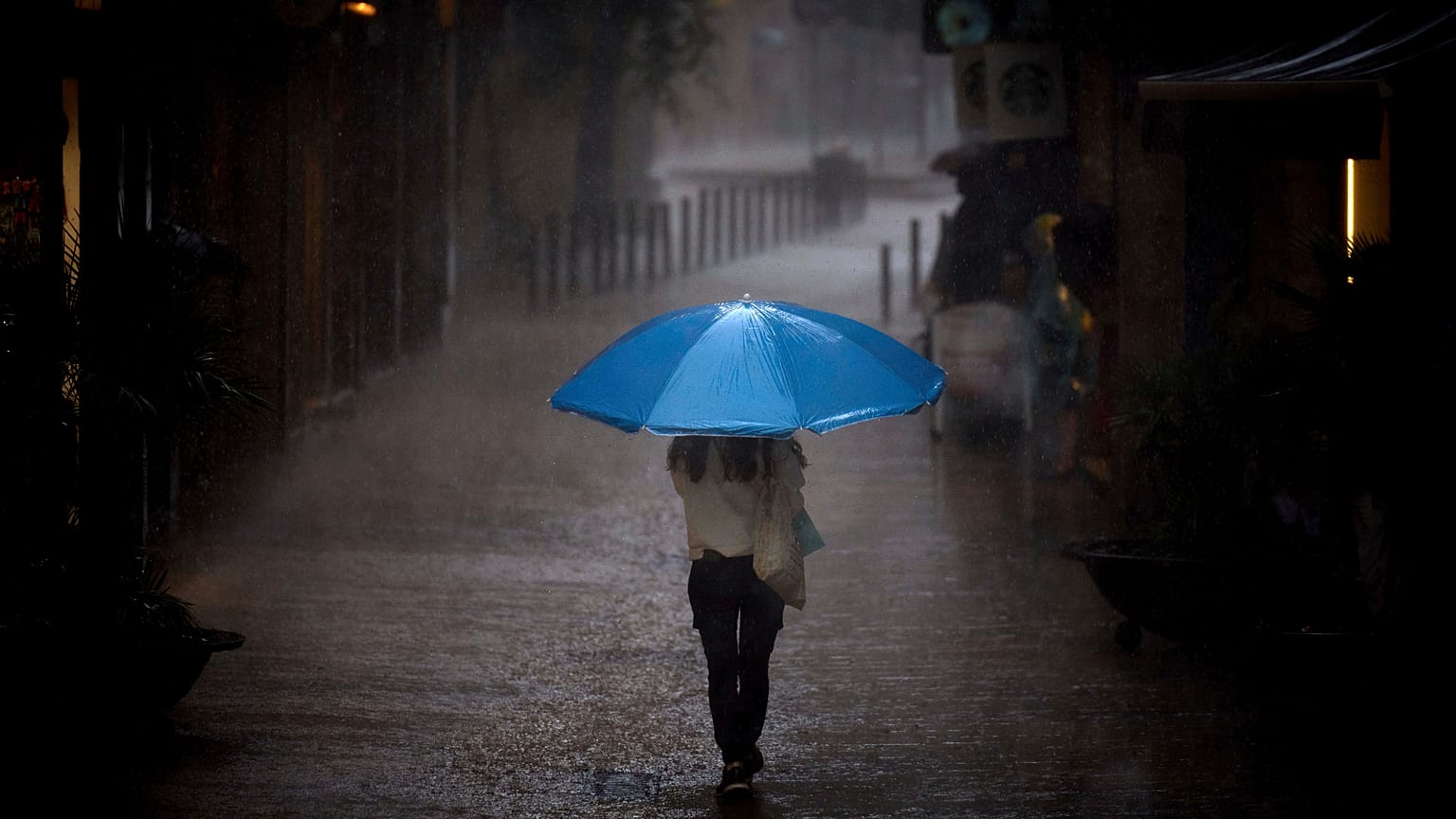 Una mujer camina bajo la lluvia en Barcelona