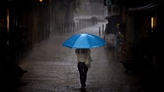 Eine Frau geht im Regen in Barcelona spazieren