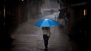 Una mujer camina bajo la lluvia en Barcelona