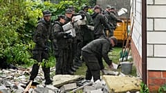 Beamte der Territorialen Verteidigung säubern das zerstörte Dach eines Hauses nach einem Angriff mehrerer russischer Drohnen in Wyryki bei Lublin, Polen, Donnerstag, 11. September 2025.